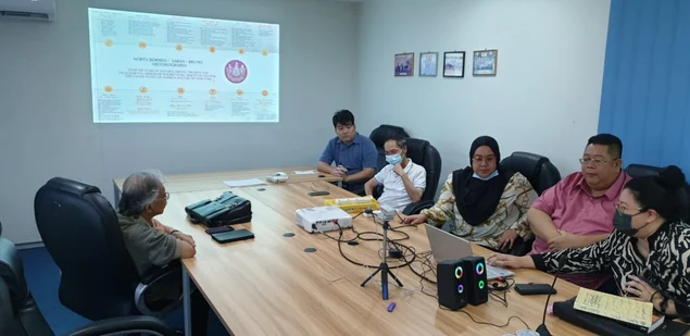 Participants gathered around a table for the presentation