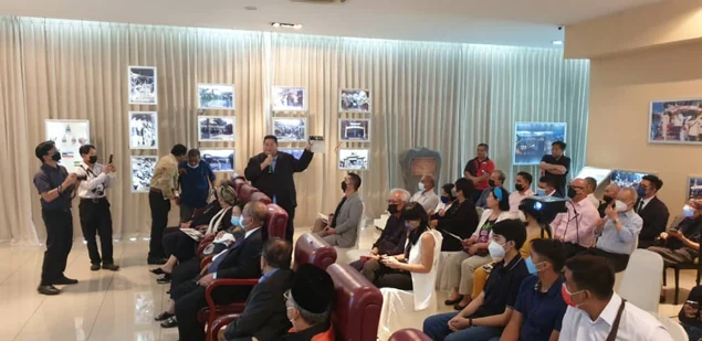 People gathered among historical photograph displays