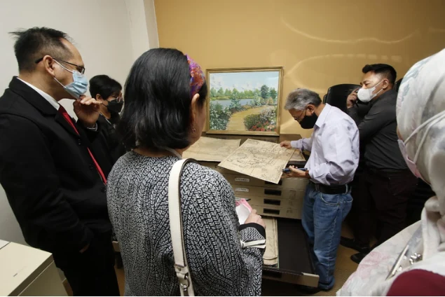 Visitors examining historical material