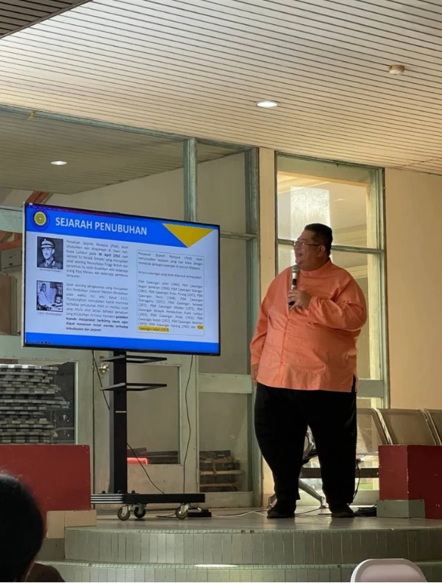 Shari Jeffri presenting beside a screen at the Sabah Sports Board