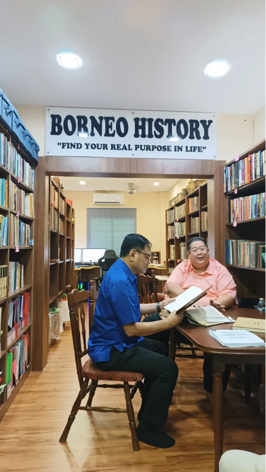 Visitors examining historical records at a table