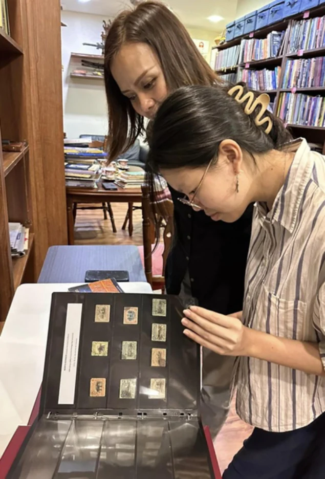 Visitors examining a stamp album
