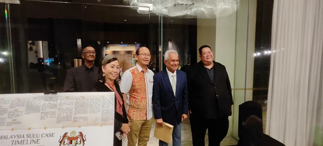 Visitors beside the Malaysia Sulu Case Timeline exhibition