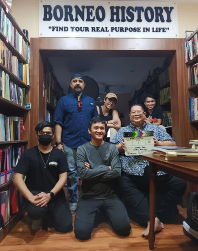 Documentary participants holding a framed presentation