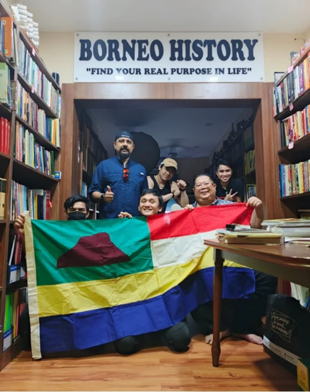 The documentary group beside the gallery flag