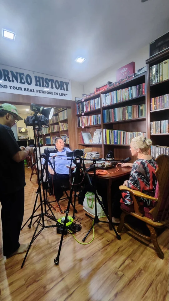 Recording a conversation among the gallery bookshelves