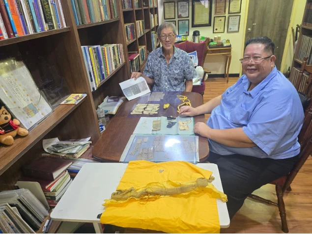 Shari Jeffri and Alex Teoh examining historical documents