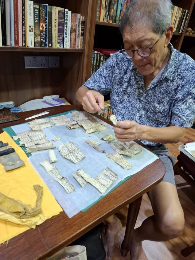 Alex Teoh examining a document