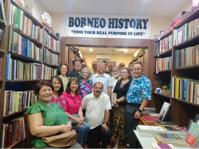 Rotary Club visitors gathered by the gallery bookshelves