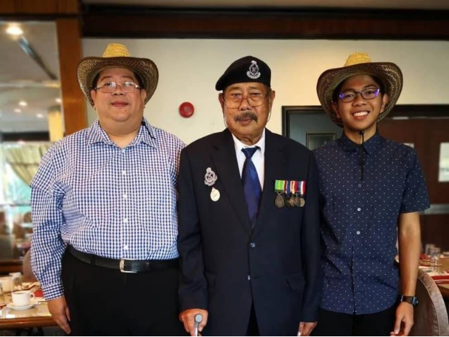 Jeffri bin Mohd Asi, centre, wearing his uniform and medals, with two companions